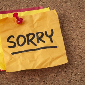sorry apology - handwriting on a orange sticky note